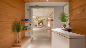 Zona de recepción con paneles de madera, mostrador de recepción y área de espera con sillas.