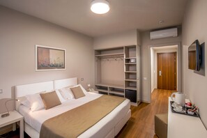 A hotel room with a bed, bedside table, a wardrobe, a desk with a tray of breakfast items, and a television. - Hotel Green Park Madama Spa & Wellness (Castel Madama)