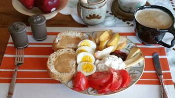A breakfast plate with eggs, bread, tomatoes, and a cup of coffee.