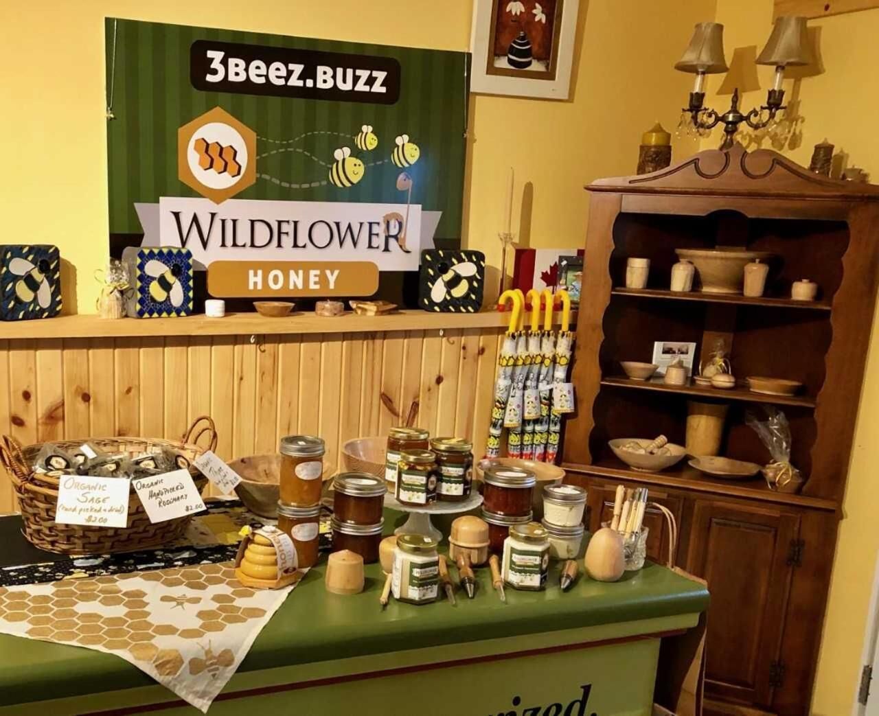 Exhibición de frascos de miel y juegos de mieleros en una tienda llamada Wildflower Honey.