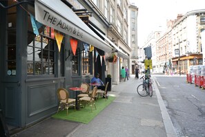 A restaurant named "The Adam & Eve" with outdoor seating and a bicycle parked nearby.