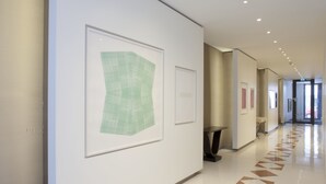 Um corredor com obras de arte emolduradas, piso estampado e design moderno e limpo.