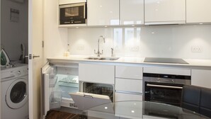 Uma cozinha moderna com eletrodomésticos de aço inoxidável, máquina de lavar louça e forno embutido.