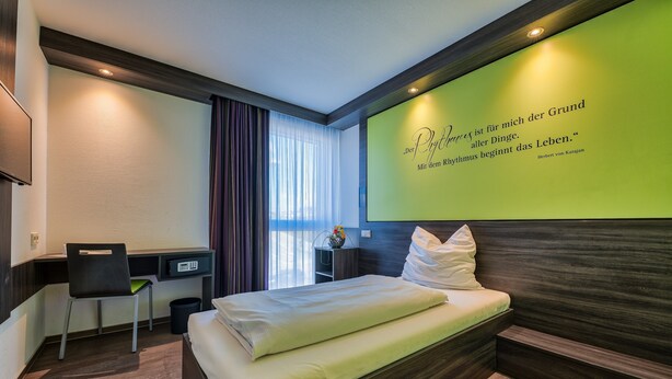 Una habitación de hotel con una cama, un escritorio y una silla.