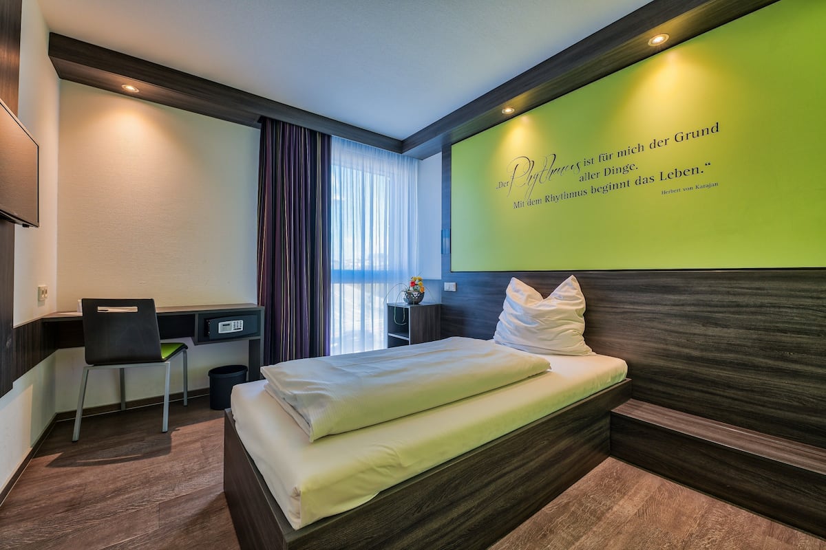 Una habitación de hotel con una cama, un escritorio y una silla.