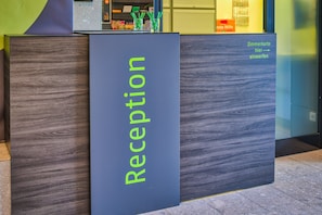 Un mostrador de recepción con un letrero que dice 'Reception' en letras verdes.