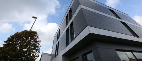 Ein modernes Gebäude mit einer geometrischen Fassade und großen Fenstern.