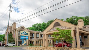 A hotel with a sign for an indoor pool, multiple balconies, and a classic red car parked in front. - Norma Dan Motel - Near Dolly Parton's Stampede Dinner Attraction (Pigeon Forge)