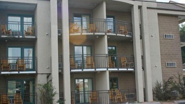 A multi-story hotel with balconies, large windows, and a parking lot in front. - Norma Dan Motel - Near Dolly Parton's Stampede Dinner Attraction (Pigeon Forge)
