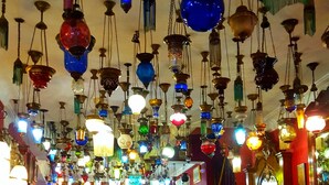 Una habitación con luces decorativas colgantes, muebles de madera y alfombra roja.