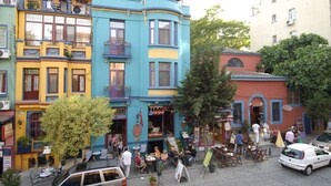 Un edificio colorido con mesas al aire libre y una cafetería.