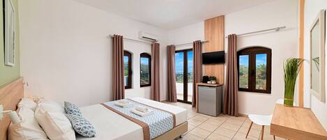A hotel room with a bed, a desk, a TV, and a view of the outdoors.