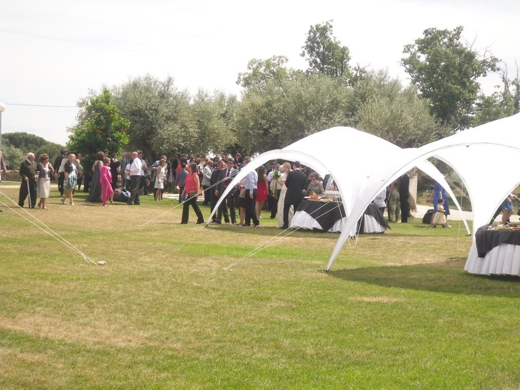 Evento al aire libre con tiendas de campaña y un campo cubierto de césped.