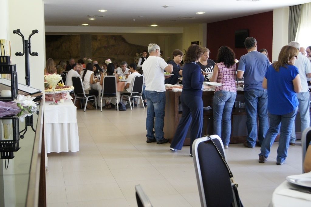 A dining area with multiple tables and chairs, a buffet setup, and a counter for service.