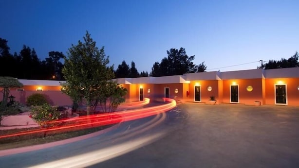Un hotel con diseño moderno, que presenta una serie de edificios conectados con entradas iluminadas.
