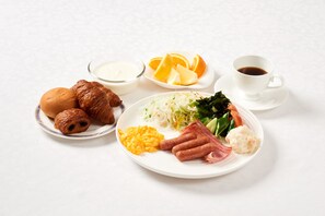 A breakfast plate with croissants, scrambled eggs, sausages, and a salad. - Marroad Inn Omiya (Saitama)