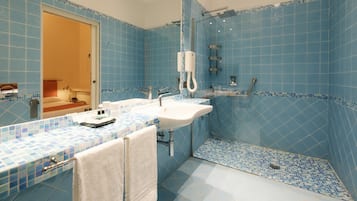 Un baño con azulejos azules, un lavabo blanco y una ducha.
