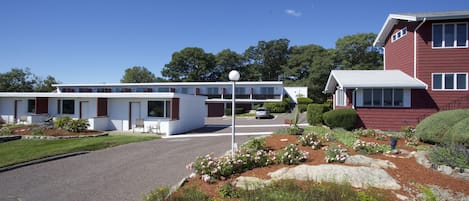 Un edificio de dos pisos con techo plano y fachada blanca.