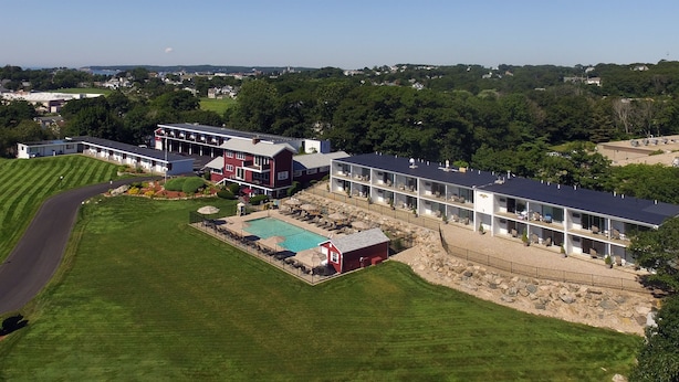 A hotel with a swimming pool, multiple guest rooms, and a red barn-like structure. - The Vista (Gloucester)