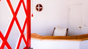 A room with a wooden counter, a white door, and a wall-mounted cross symbol.
