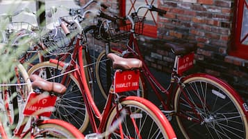 A red bicycle with a "I ♥ HAMLET INN" sign, parked in front of a brick building with a red door.