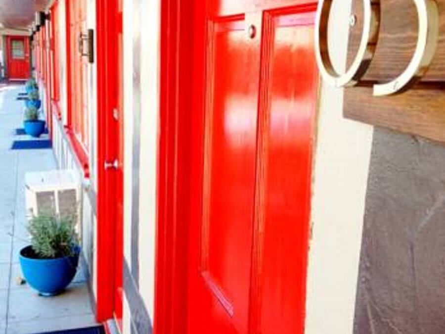 A row of red doors with a number '05' sign, suggesting a hotel or lodging establishment.