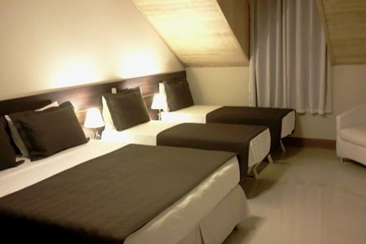 Une chambre d’hôtel avec deux lits, un bureau et une chaise.