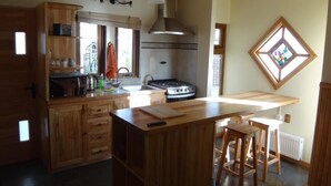 A kitchen with wooden cabinets, a stove, and a large window.