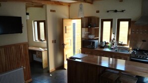 A kitchen with wooden cabinets, a built-in microwave, a stove, and a large island with bar stools.