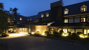 A hotel with a traditional architectural style, featuring a prominent entrance with a well-lit facade and a sign indicating it is a hotel. - Marroad Hakone (Hakone)