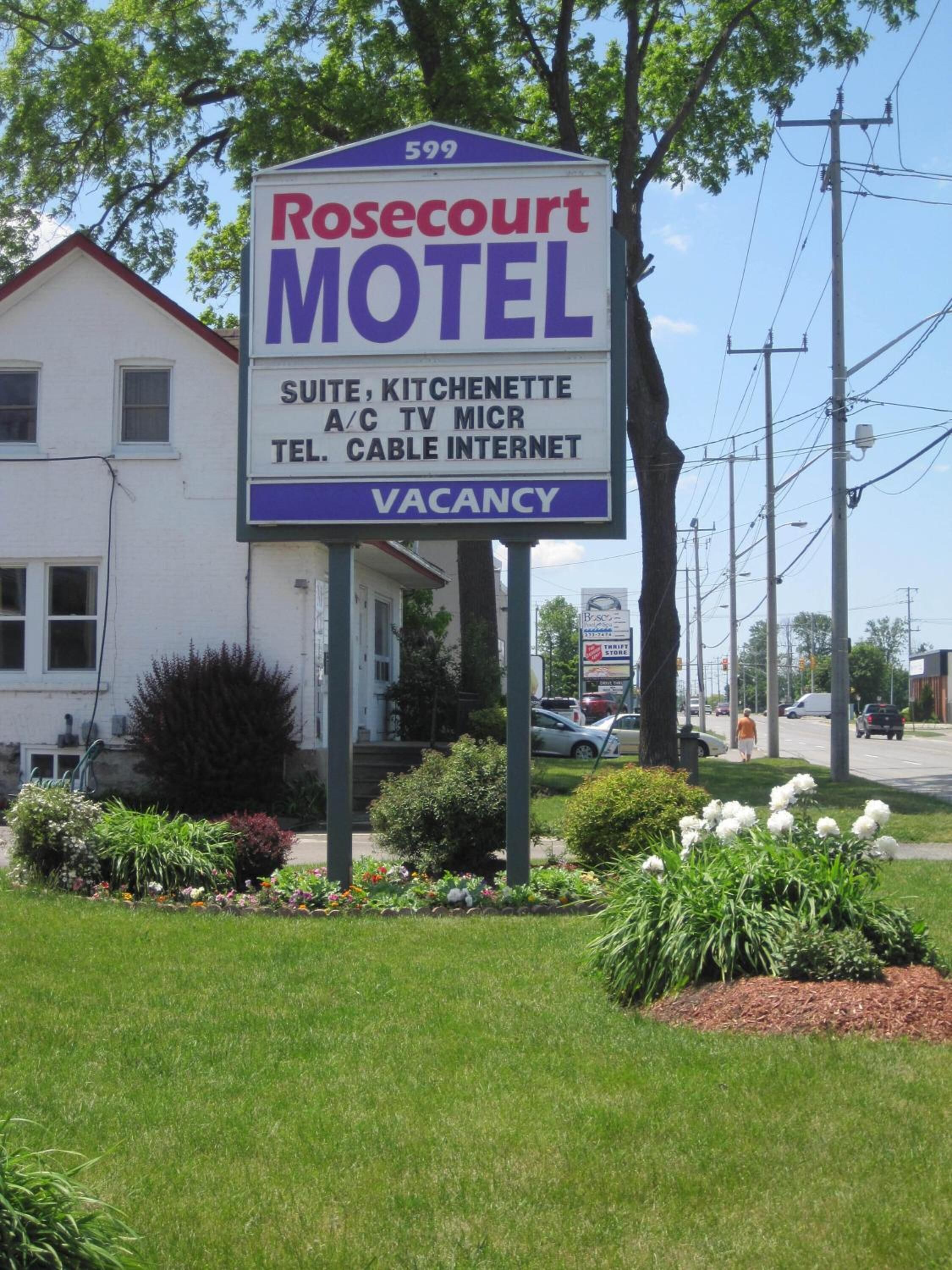 Señal del motel Rosecourt con servicios que incluyen suite, kitchenette, TV, MICR, teléfono, cable e internet.