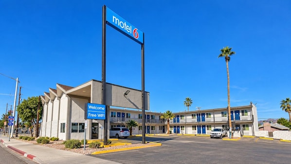 A motel with a sign indicating 'motel 6' and a welcome sign for 'Free WIFI'.
