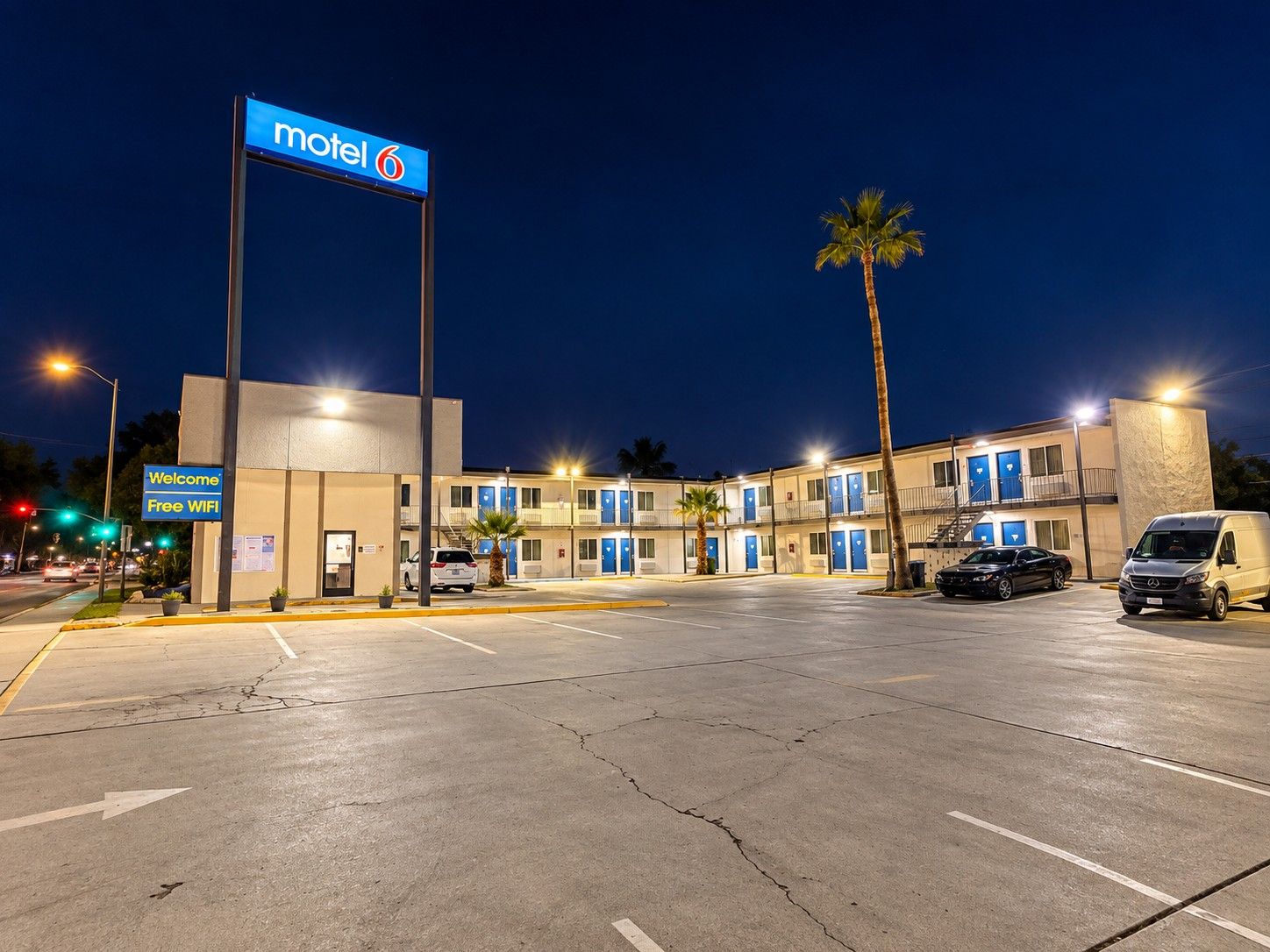 Un motel con un cartel que indica 'motel 6' y un letrero de bienvenida que ofrece WiFi gratuito.