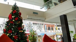 A modern interior with a Christmas tree, red seating, and a unique spherical light fixture. - Hotel French Ipoh (Ipoh)