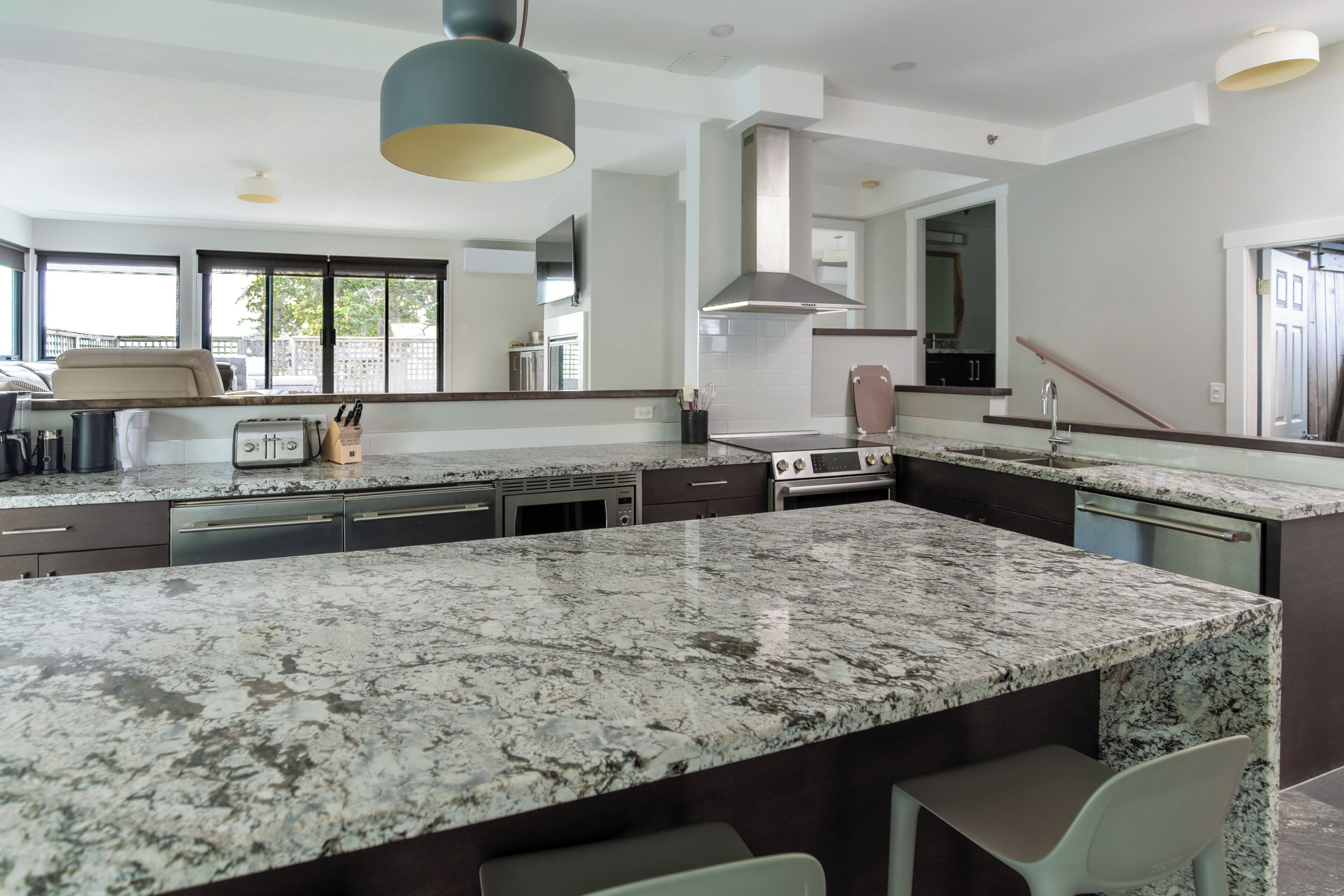 A modern kitchen with granite countertops, stainless steel appliances, and a large island.