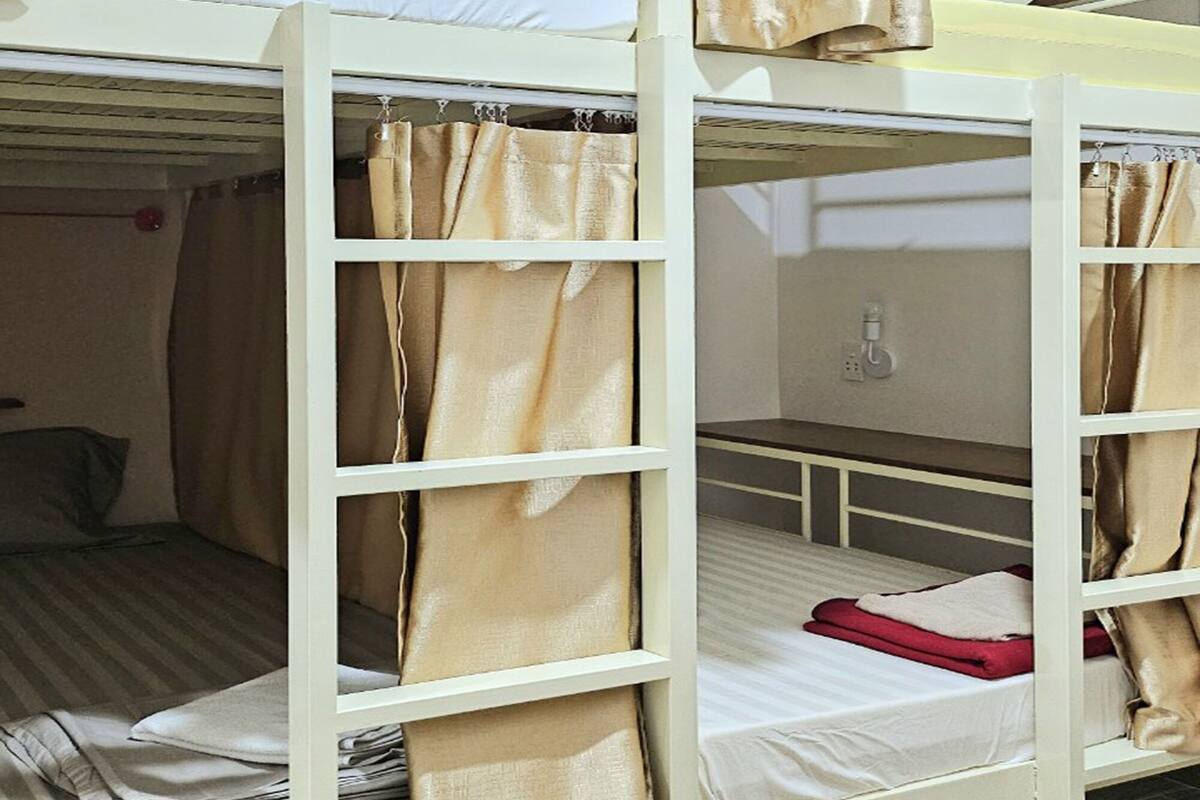 Quarto com beliche, uma mesinha e uma cadeira.