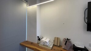 A modern bathroom with a wooden shelf holding towels, a remote control, and a tissue box. - Charging station, pet-friendly pool Luodong, nice homestay (Luodong)