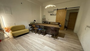 A compact living space with a sofa, a dining area with chairs, a kitchen counter, and a wooden door. - Charging station, pet-friendly pool Luodong, nice homestay (Luodong)