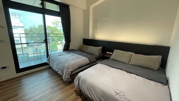 A hotel room with two beds, a large sliding glass door to the balcony, and a modern design. - Charging station, pet-friendly pool Luodong, nice homestay (Luodong)