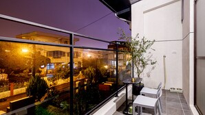 A balcony with a view of a cityscape at night, a potted plant, and a small table with chairs. - Charging station, pet-friendly pool Luodong, nice homestay (Luodong)
