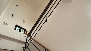 A staircase with wooden steps and black metal railings, leading to a landing with a door and a window. - Charging station, pet-friendly pool Luodong, nice homestay (Luodong)