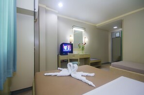 Una habitación de hotel con cama, televisión, espejo y escritorio.