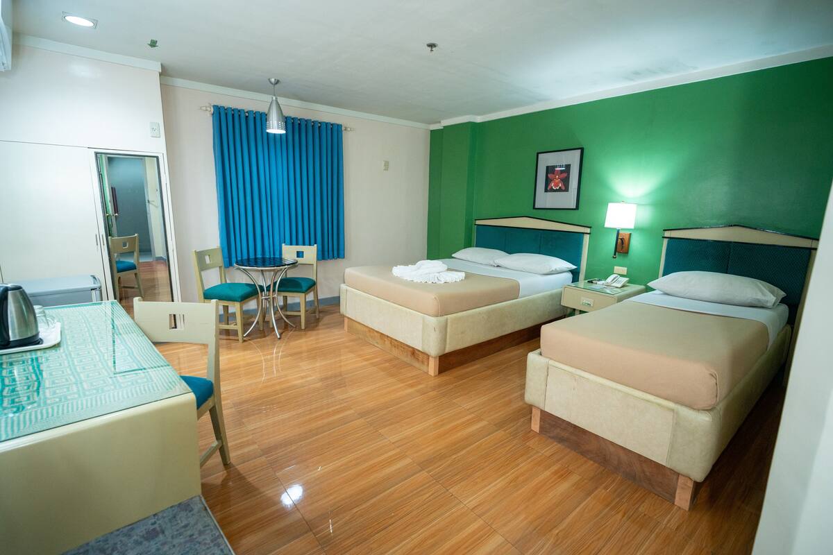 Een hotelkamer met twee bedden, een bureau, een stoel en een eettafel.