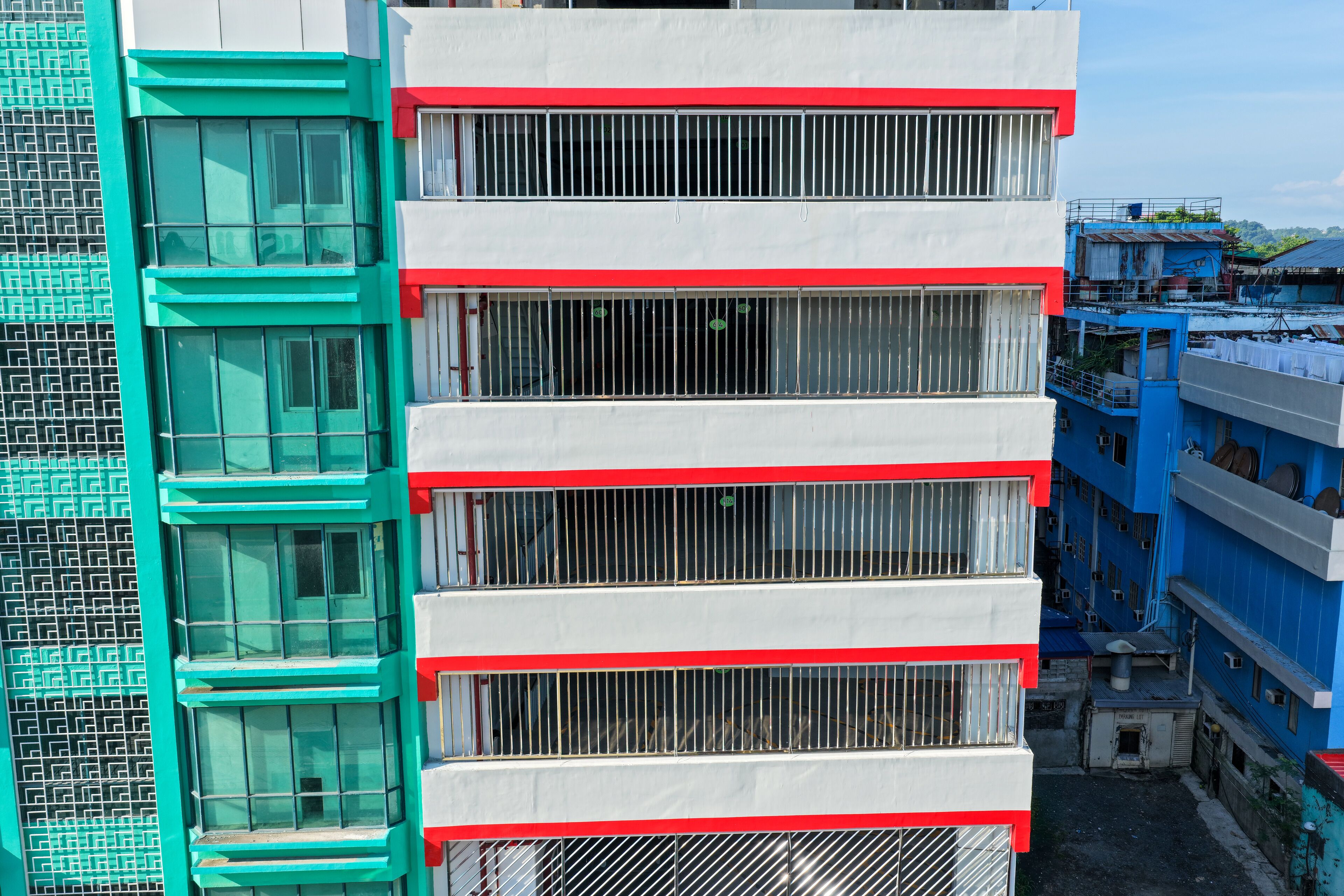 A multi-story building with a modern design, featuring a combination of glass and metal elements, and a prominent red and white color scheme.