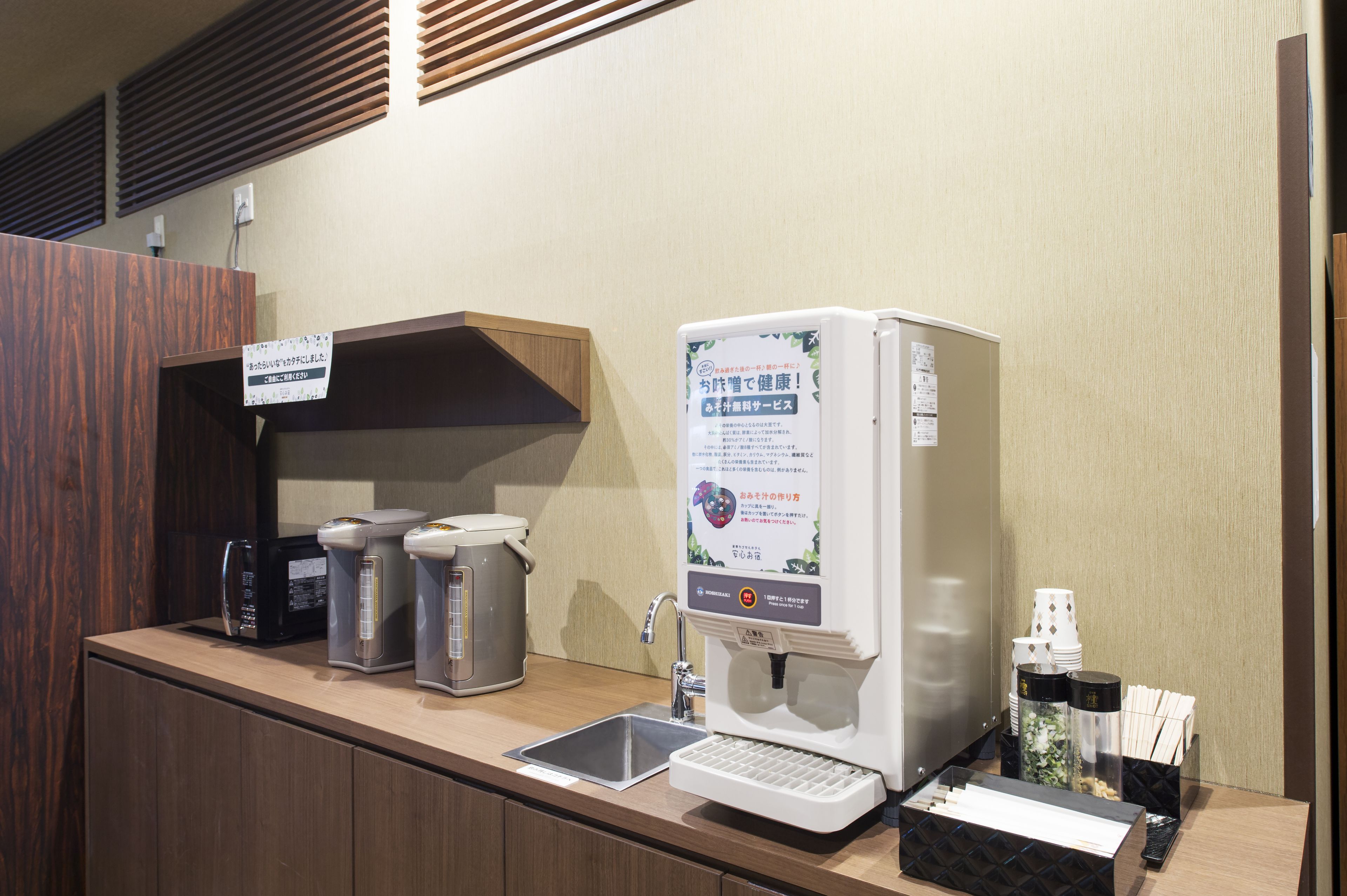 A kitchenette with a coffee maker, a microwave, a toaster, and a sink.