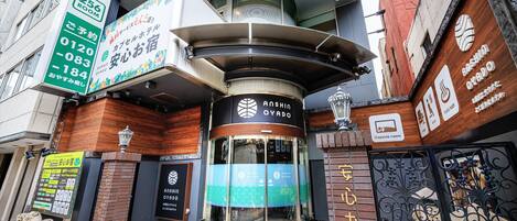 A building with a sign for '256 ROOM' and 'Anshin Oyado' on the facade.
