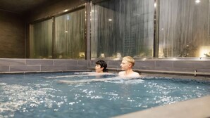 A swimming pool with two people in the water.