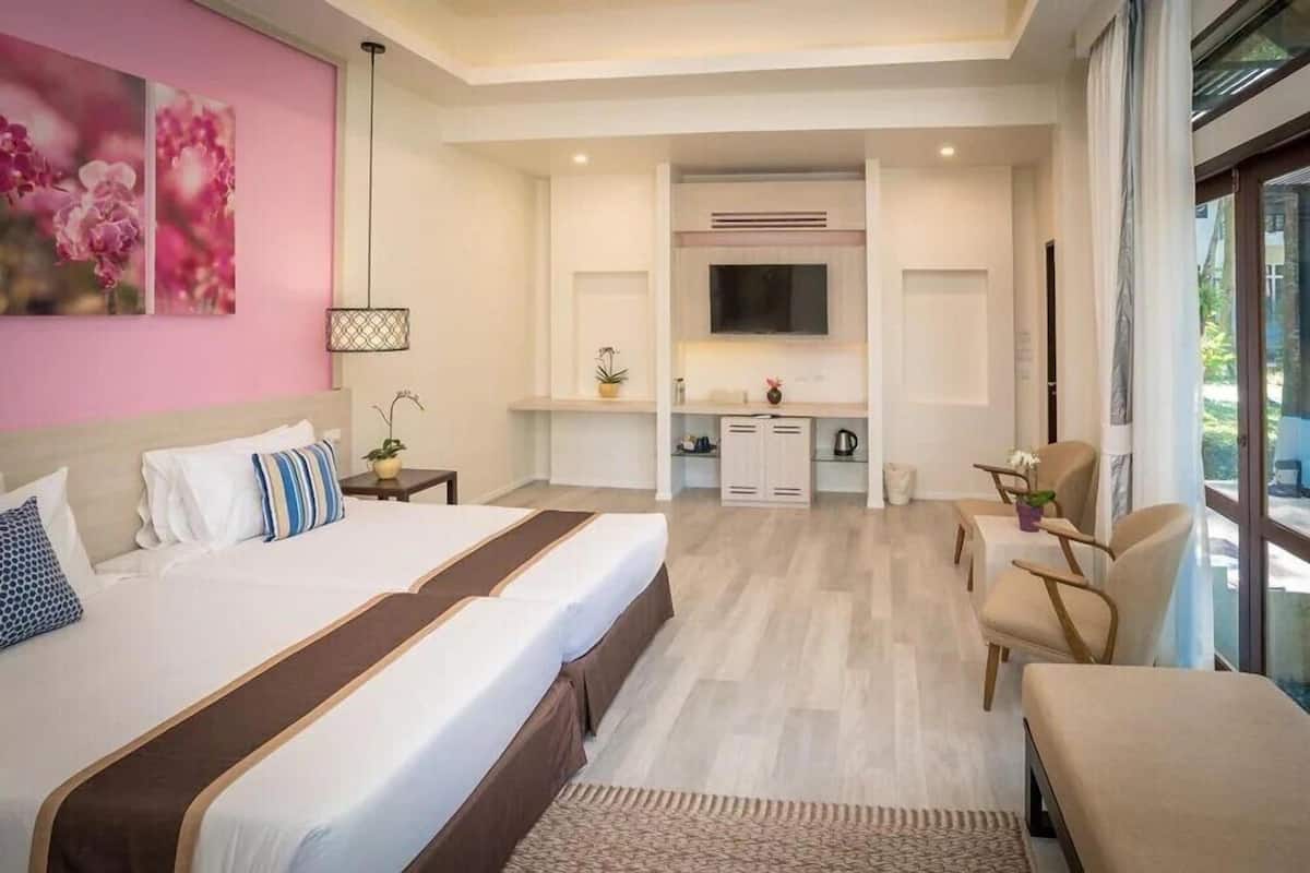 Een moderne hotelkamer met een groot bed, een bureau en een zithoek.