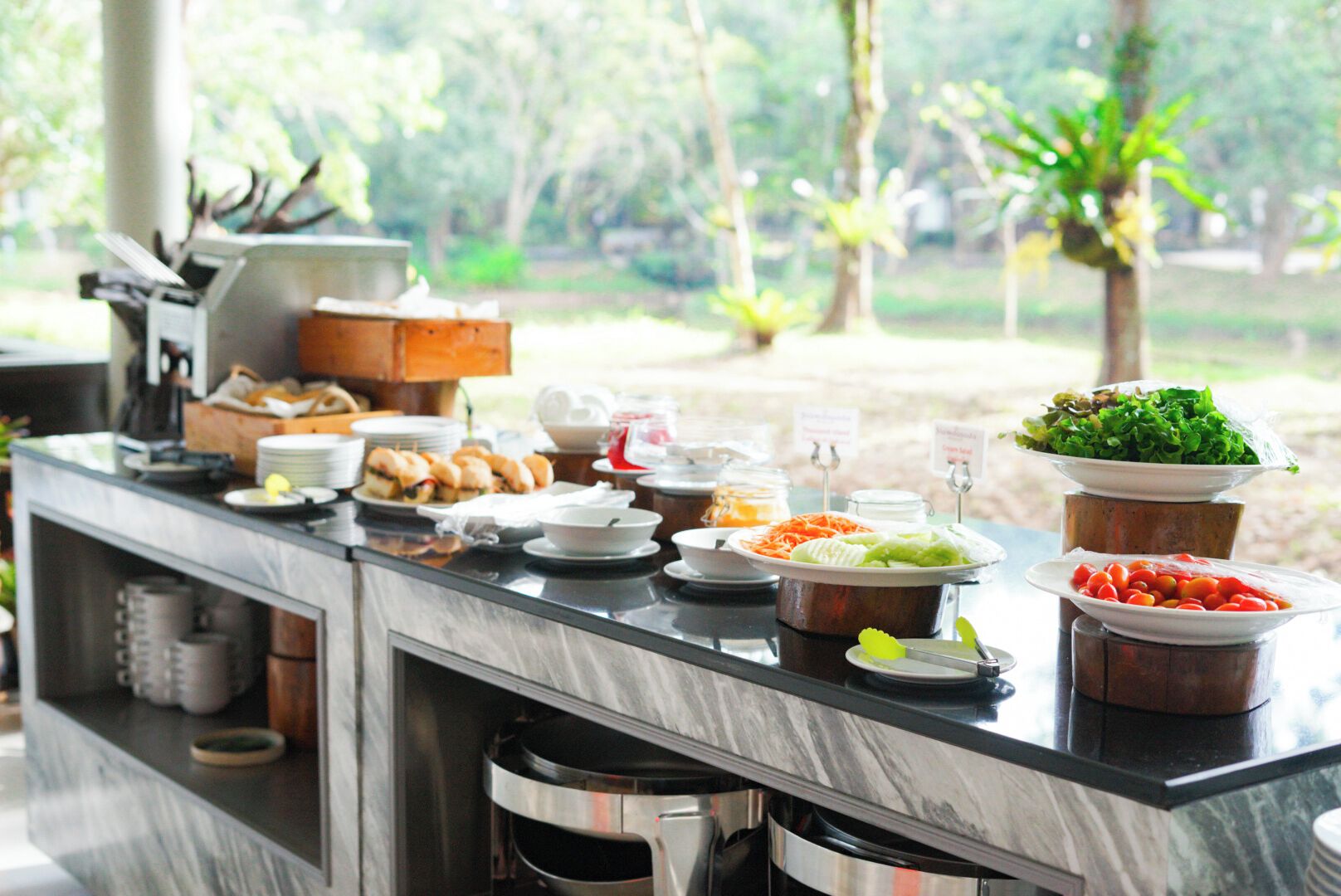 A buffet setup with various food items and condiments.