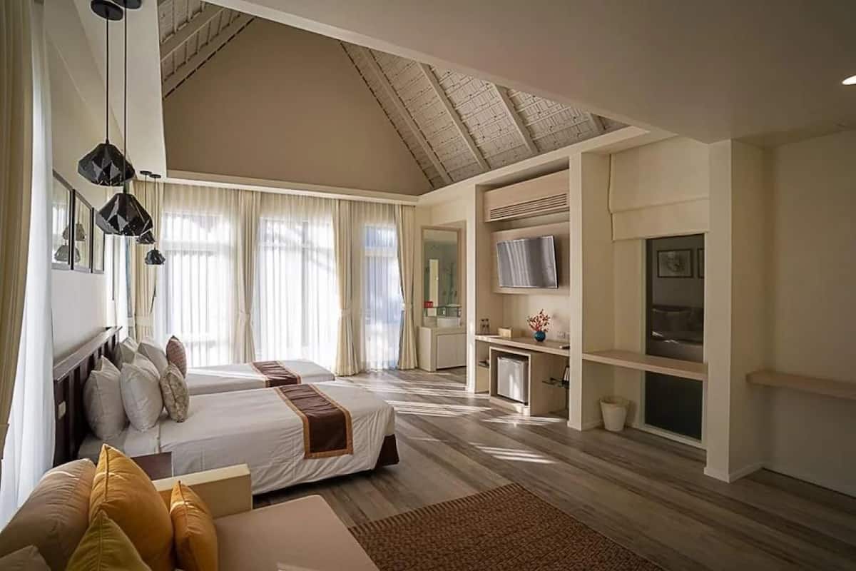 Een hotelkamer met een groot bed, een bureau, een televisie en een kitchenette.